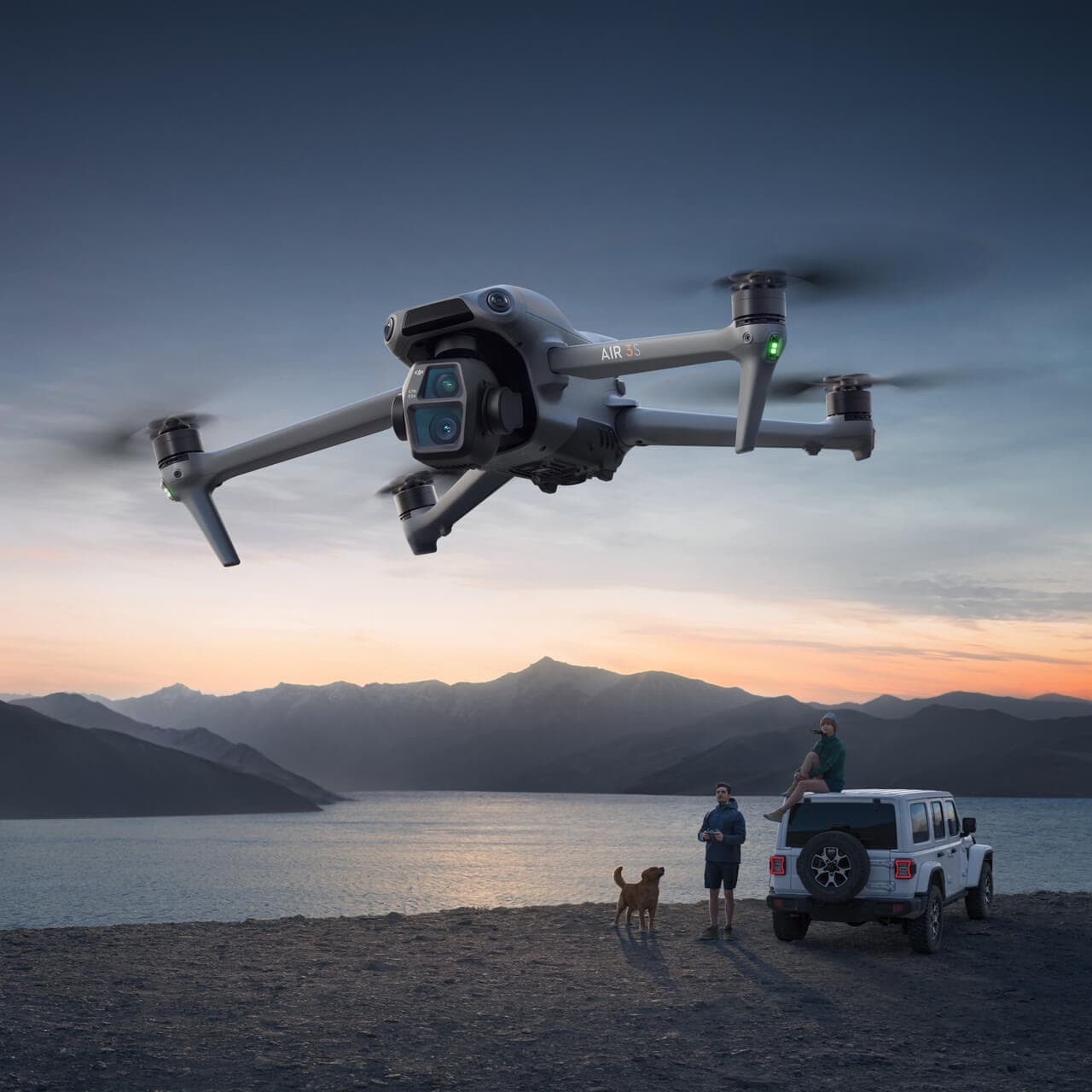 DJI Air 3S flying above a lakeside landscape at dusk